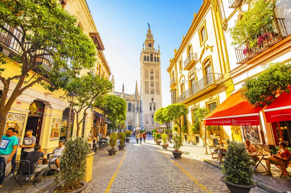 visitar sevilla en febrero con guia local foto calle con gente y giralda